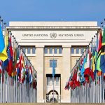 United Nations building with numerous national flags outside.