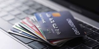 Stack of credit cards on a laptop keyboard.