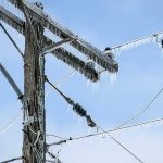 Icicles hanging from power lines and pole.