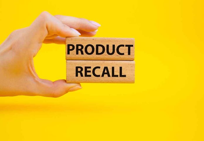 Hand holding "Product Recall" blocks on yellow background.