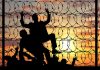 Silhouetted people climbing barbed wire fence sunset background