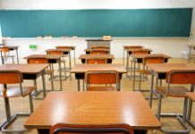 Empty classroom with desks and a chalkboard.