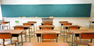 Empty classroom with desks and a chalkboard.