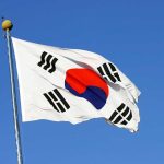 South Korean flag waving against clear blue sky.