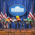 Multiple microphones at White House press briefing podium.