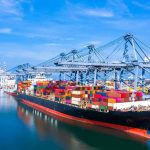 Container ship docked at a busy industrial port.