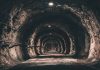 Dimly lit underground tunnel with rocky walls.