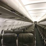 Empty airplane cabin with rows of seats.