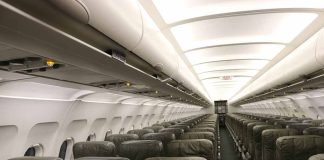 Empty airplane cabin with rows of seats.