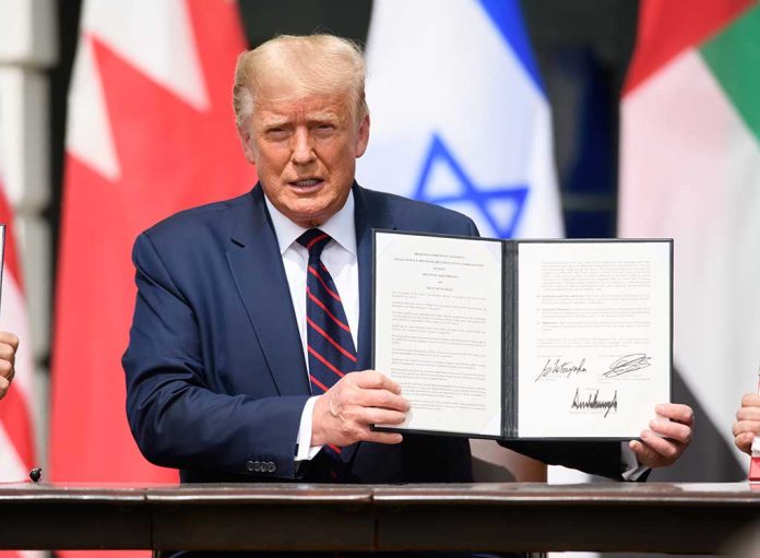 Man holding signed agreement with flags in background