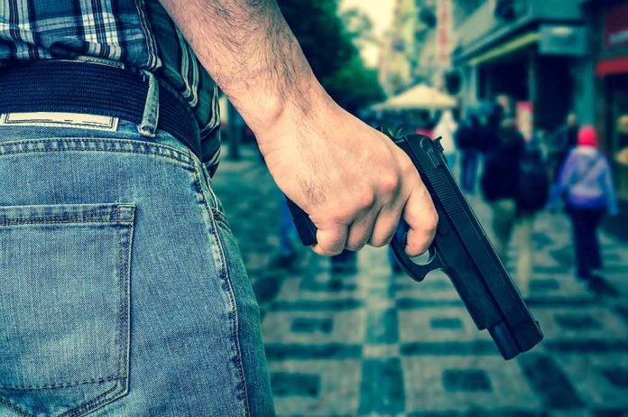 Person holding a gun in a crowded street.