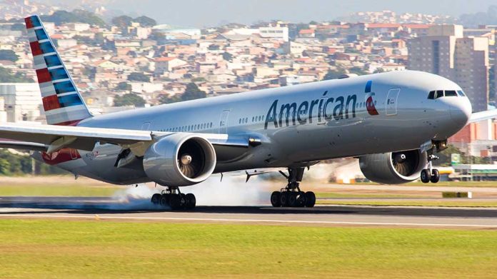 Airplane landing on runway with cityscape background.