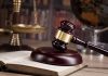 Gavel on book beside scales of justice