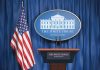 White House podium with American flag and seal.