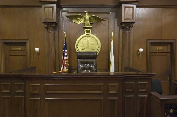 Empty courtroom with judge's chair and American flag.