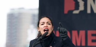 Person speaking passionately at an outdoor podium event