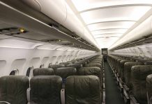 Empty airplane cabin with green seats.