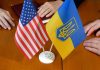 American and Ukrainian flags on wooden table meeting