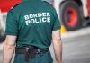 Person in "Border Police" uniform standing outdoors.