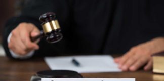 Judge with gavel and Supreme Court nameplate.