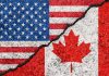 USA and Canada flags divided by a crack