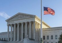 US flag flying outside a neoclassical government building