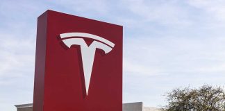 Tesla sign in front of dealership.