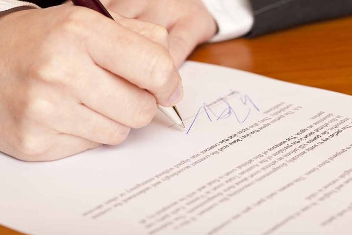 Person signing a document with a pen