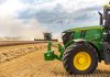 A green tractor in a wheat field.