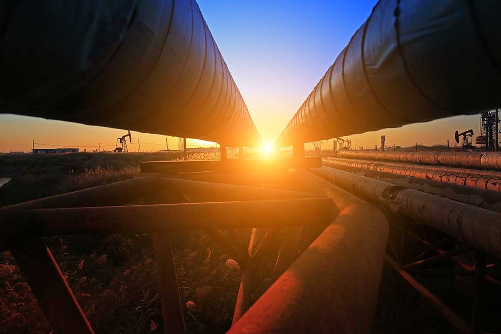 Sunset between two large industrial pipelines outdoors
