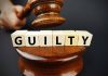 Gavel striking blocks spelling guilty