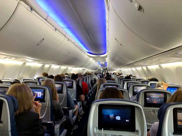 1373718830 featured image Airplane cabin with passengers and in-flight entertainment screens.