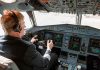 Pilot in cockpit operating airplane controls.
