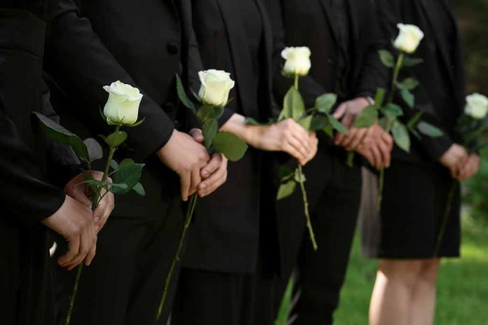 2346413087 featured image People in black holding white roses in a line.