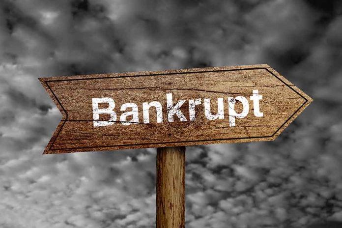 243618139 featured image "Bankrupt" sign against cloudy sky background.