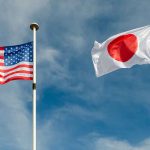 USA and Japan flags flying on flagpoles