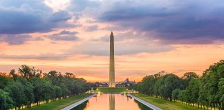 Monument and reflecting pool at sunset with trees