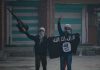 People holding and waving a black flag.