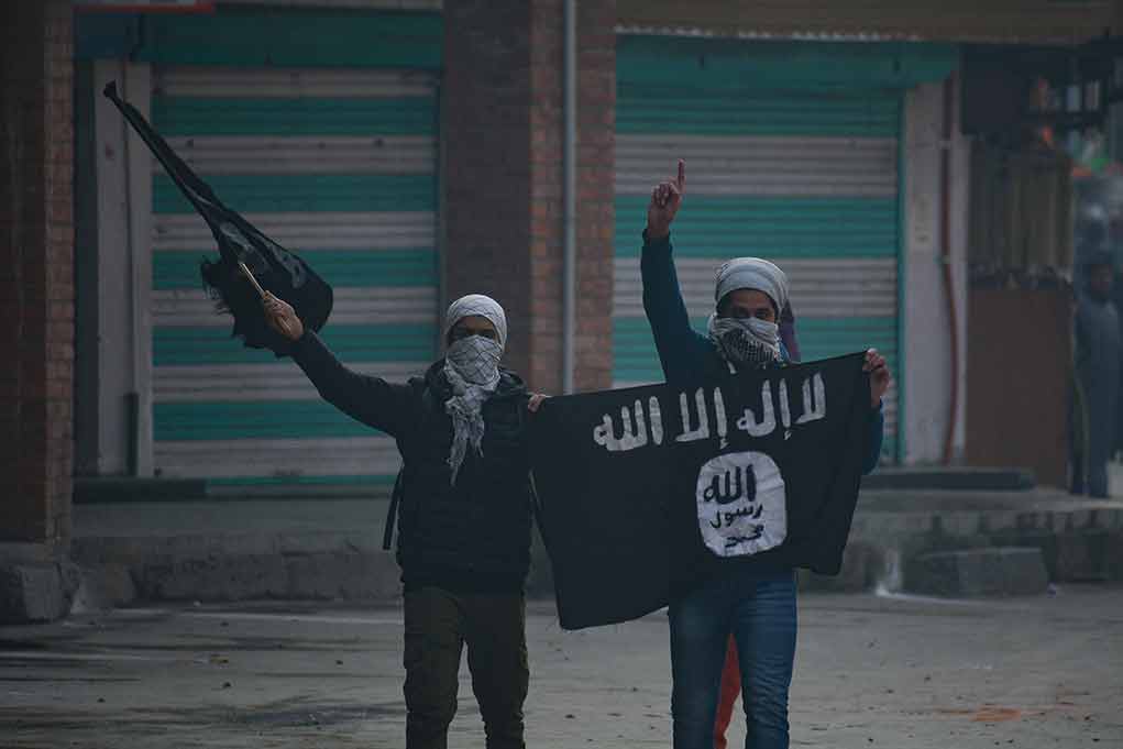 People holding and waving a black flag