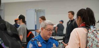 TSA agent checks passenger s documents at airport security