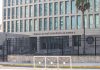 US Embassy building with fence and palm tree