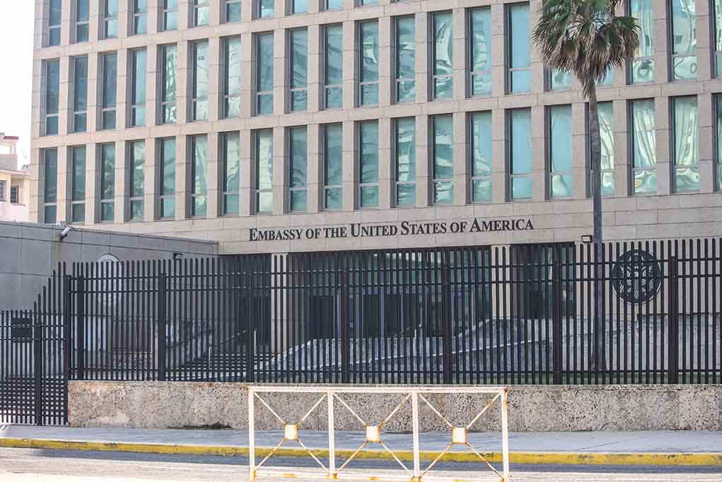US Embassy building with fence and palm tree