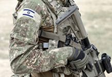 Soldier in camouflage gear with Israeli flag patch