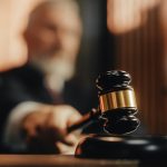 Judge holding gavel in a courtroom setting