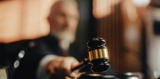 Judge holding gavel in a courtroom setting