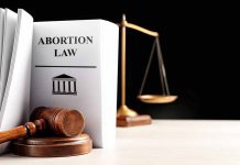 Gavel and abortion law book next to scales