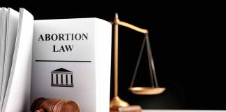 Gavel and abortion law book next to scales