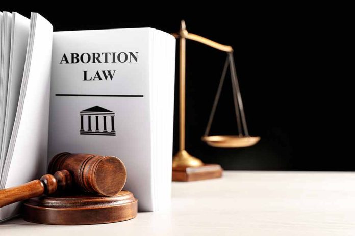 2250880469 featured image Gavel and abortion law book next to scales