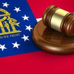 Georgia flag and judge's gavel on wooden base