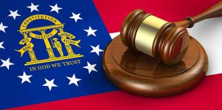 Georgia flag and judge's gavel on wooden base
